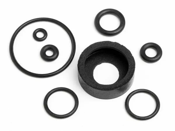 A set of black O-rings of various sizes and a dust protection cover for a model engine.