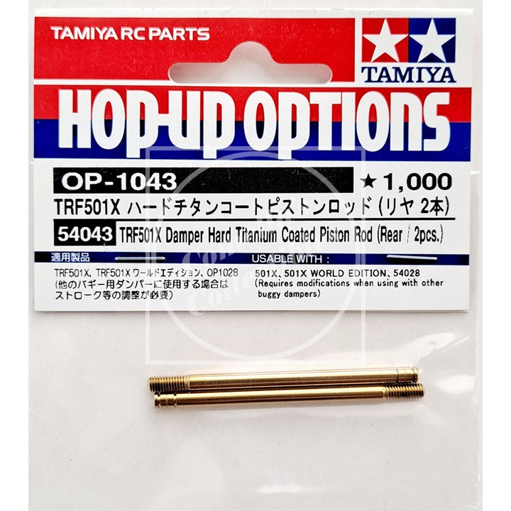 Tamiya RC parts packaging with two gold piston rods on a white background