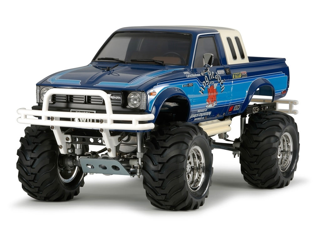 A remote control toy truck with a blue body, white front bumper, and large black tires, designed to resemble a Toyota Bruiser.