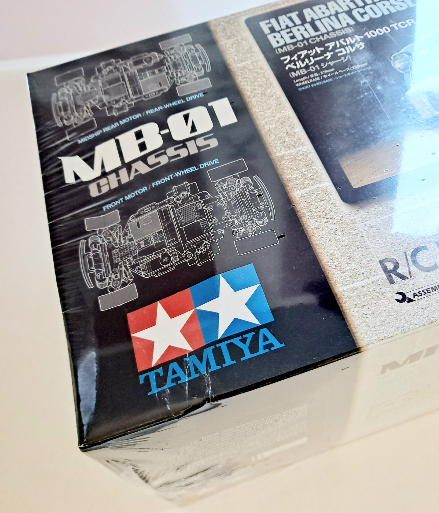 Tamiya model chassis packaging with Tamiya logo on a light background