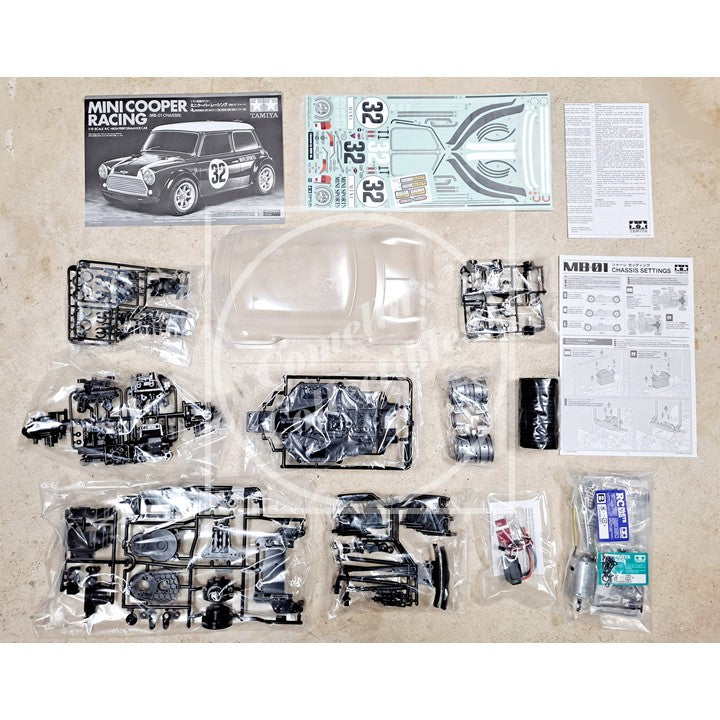 Model car kit with various parts and instructions on a beige surface