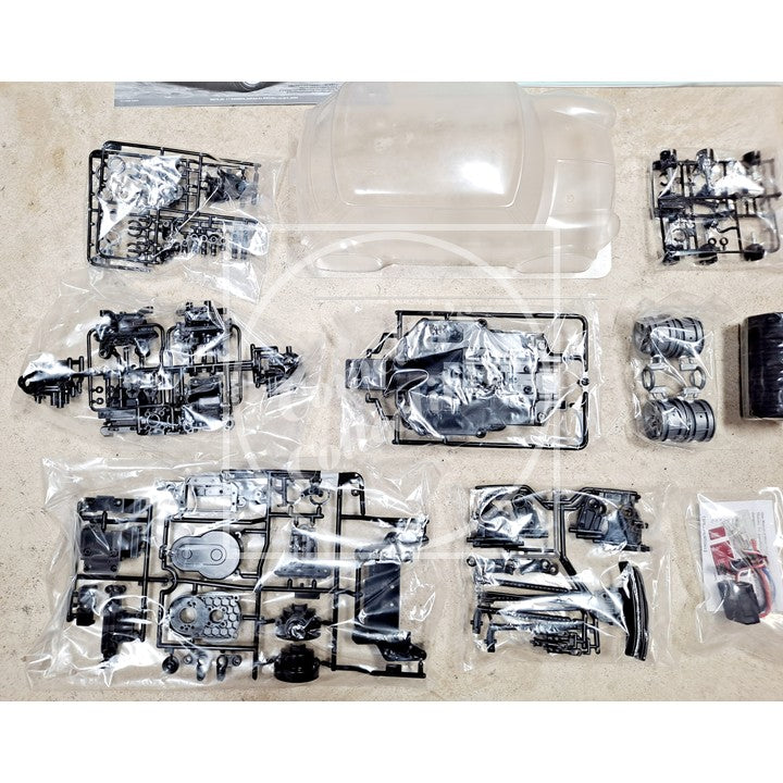 Set of model car parts in clear plastic packaging on a beige surface