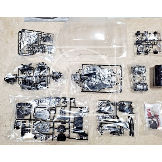 Set of model car parts in clear plastic packaging on a beige surface
