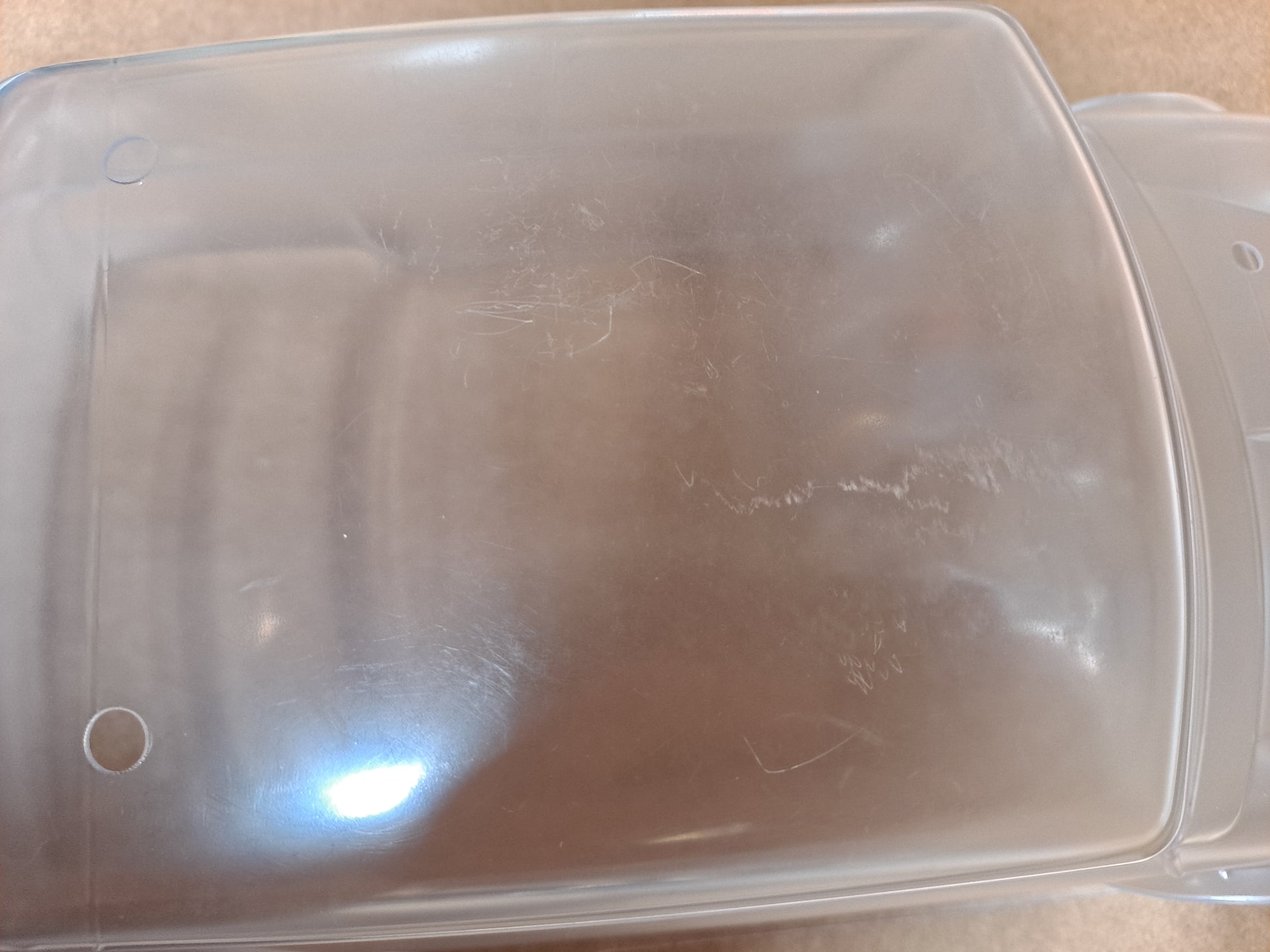 Clear plastic container with a lid on a beige surface