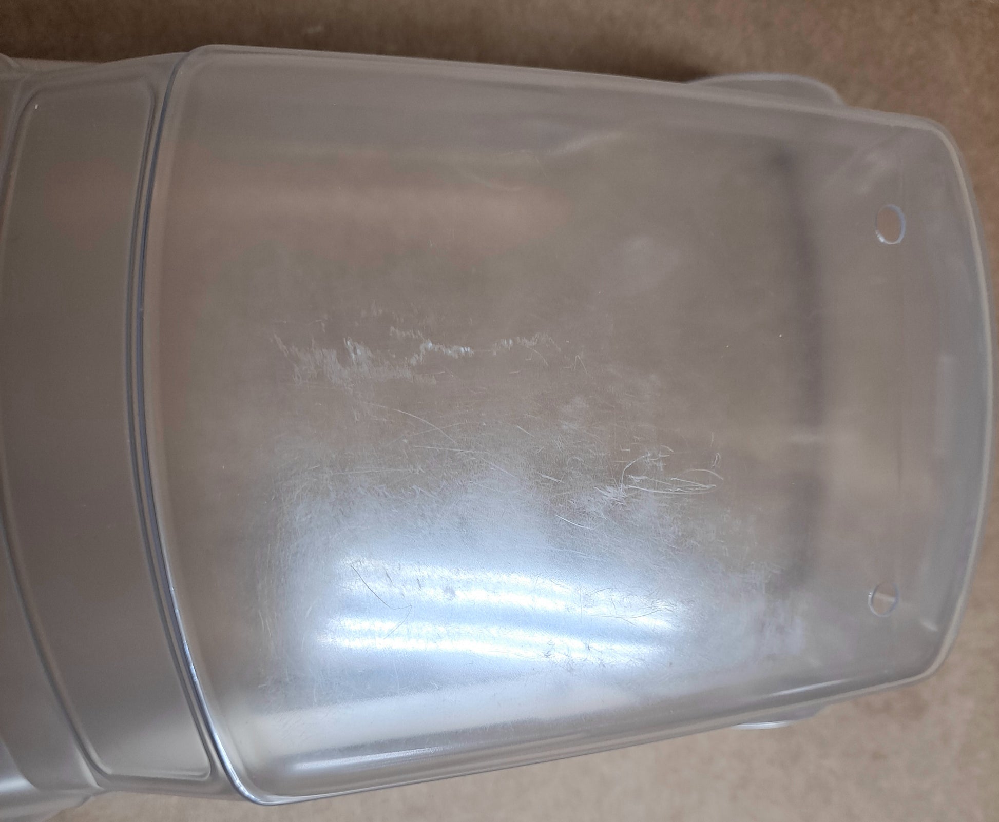 Clear plastic container with a lid on a brown surface